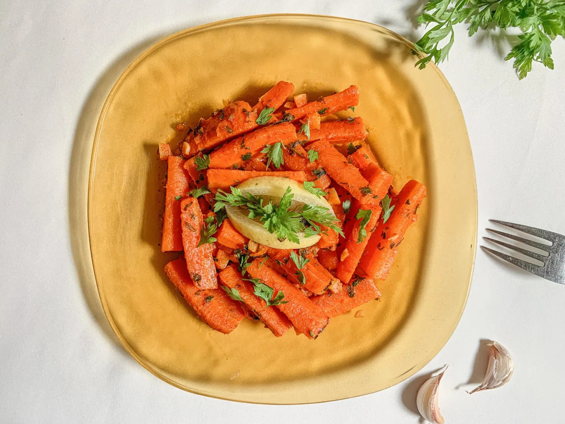 Moroccan cooked carrot salad with parsley and lemon on a gold plate